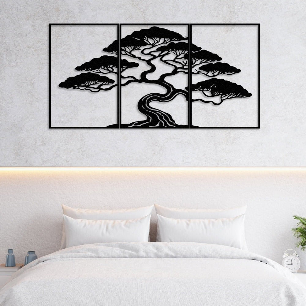 Three-piece black metal wall art featuring a bonsai tree with intricate details, mounted on a textured light wall above a neatly made bed. The bed features crisp white bedding, flanked by minimalist nightstands holding small vases and a clock. Subtle warm lighting enhances the serene bedroom ambiance.