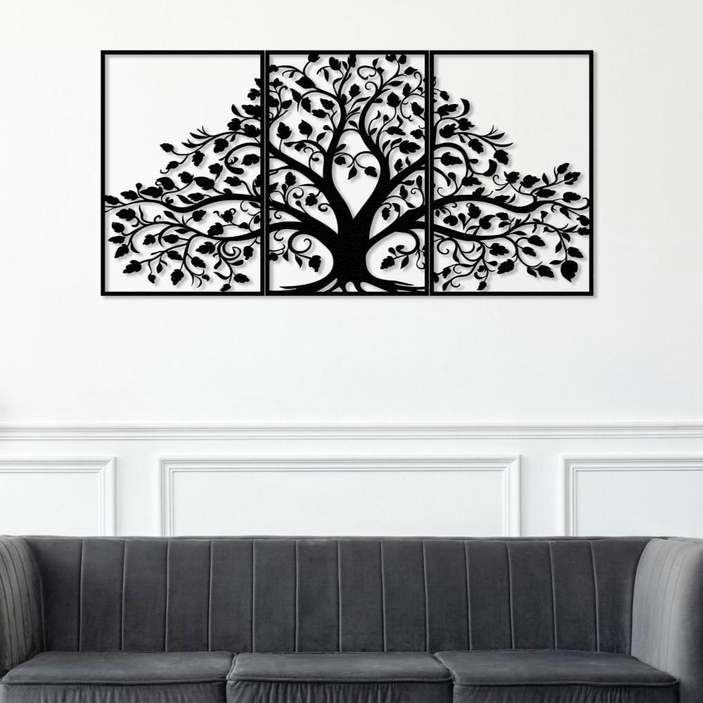 Three-piece black metal wall art featuring a life tree with detailed branches and leaves, mounted on a white wall with decorative paneling. Below the artwork, a modern gray tufted sofa adds a touch of sophistication to the space.
