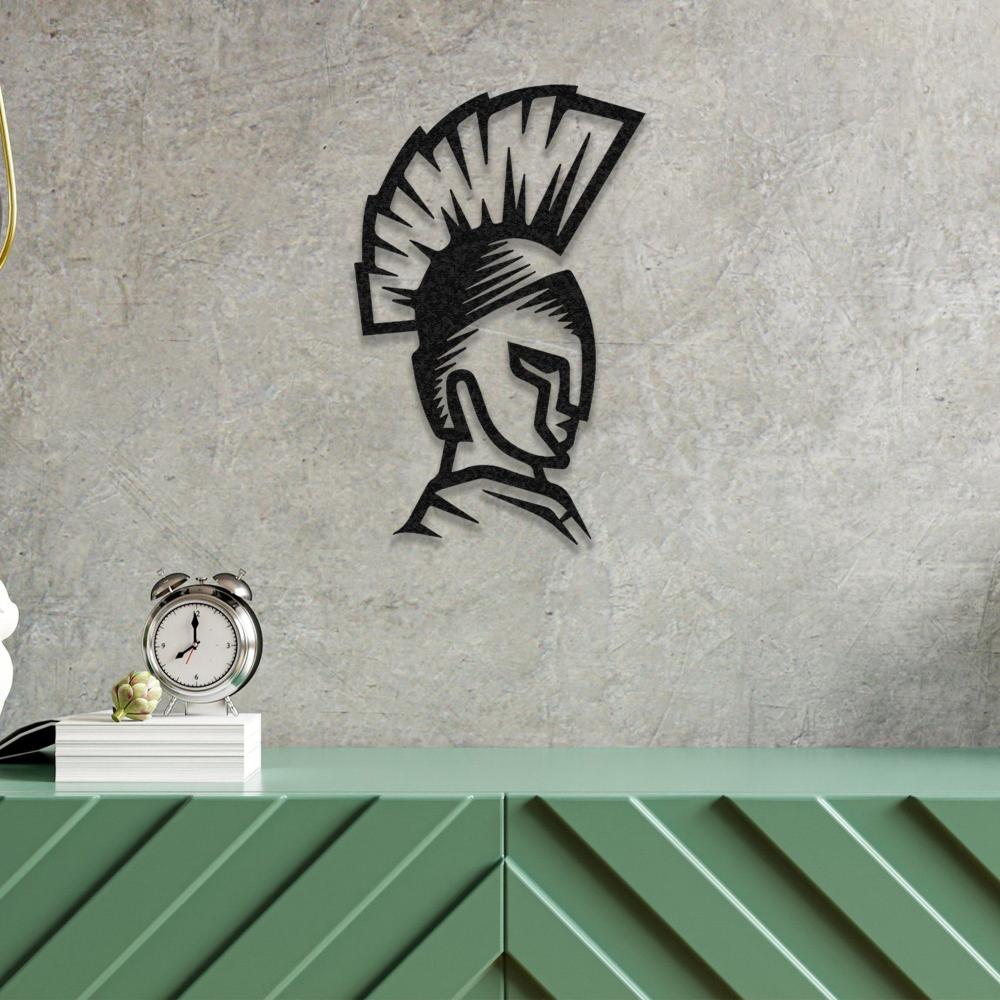 Spartan helmet metal wall art mounted on a textured concrete wall above a green console table with a clock and books.