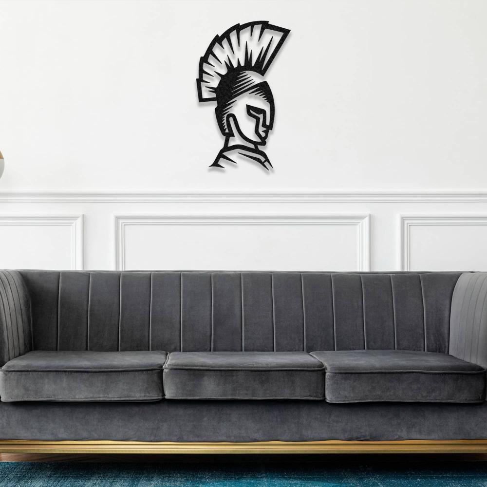 Black metal Spartan helmet wall art displayed above a dark gray couch in a minimalist living room.