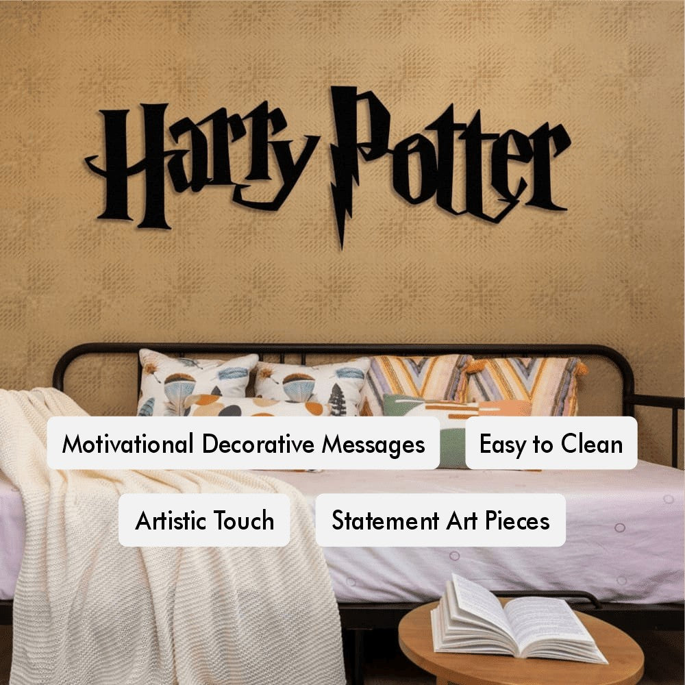 A cozy bedroom featuring a black Harry Potter-themed metal wall art on a beige textured wall above a black-framed bed. The bed has white bedding, a knitted blanket, and geometric-patterned pillows. A wooden side table holds an open book. Tags highlight features like “Motivational Decorative Messages” and “Statement Art Pieces.”