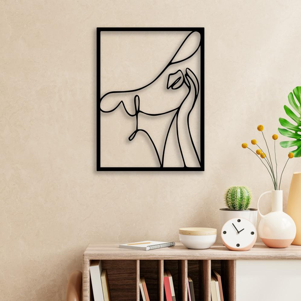 Abstract woman with a hat black metal wall art mounted on a beige wall, styled with modern decor, including a clock and potted plants.