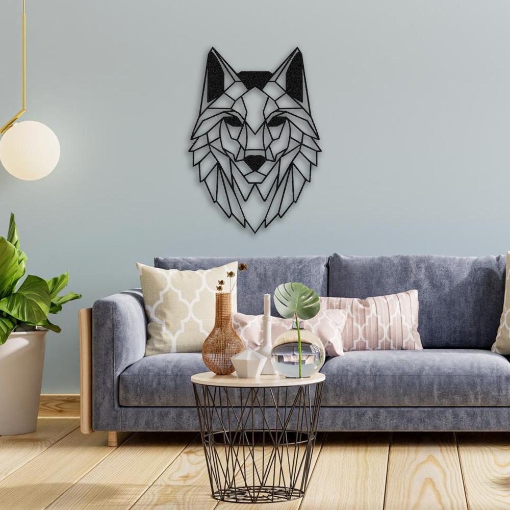Black geometric wolf head metal wall art on a light blue wall above a modern gray-blue velvet sofa, accented with decorative pillows in beige and blush tones. In front of the sofa, a black wireframe coffee table with a light wood top holds various decor items, including a vase, candle, and a tropical leaf. A potted green plant is placed to the side, and a hanging globe lamp adds a warm touch.