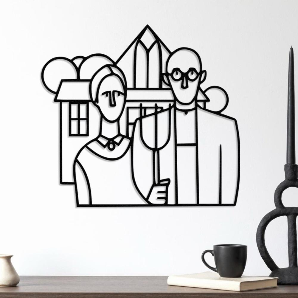 Metal wall art depicting the American Gothic painting design in black, hung on a minimalist white wall above a wooden table with a black mug and a modern candle holder, creating a contemporary look.