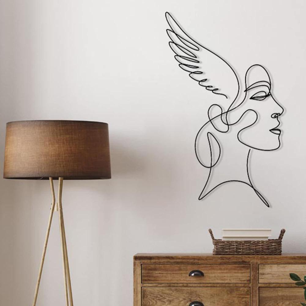 A minimalist wooden dresser complemented by a sleek standing lamp and potted plants, featuring angelic winged woman wall art in a serene setting.