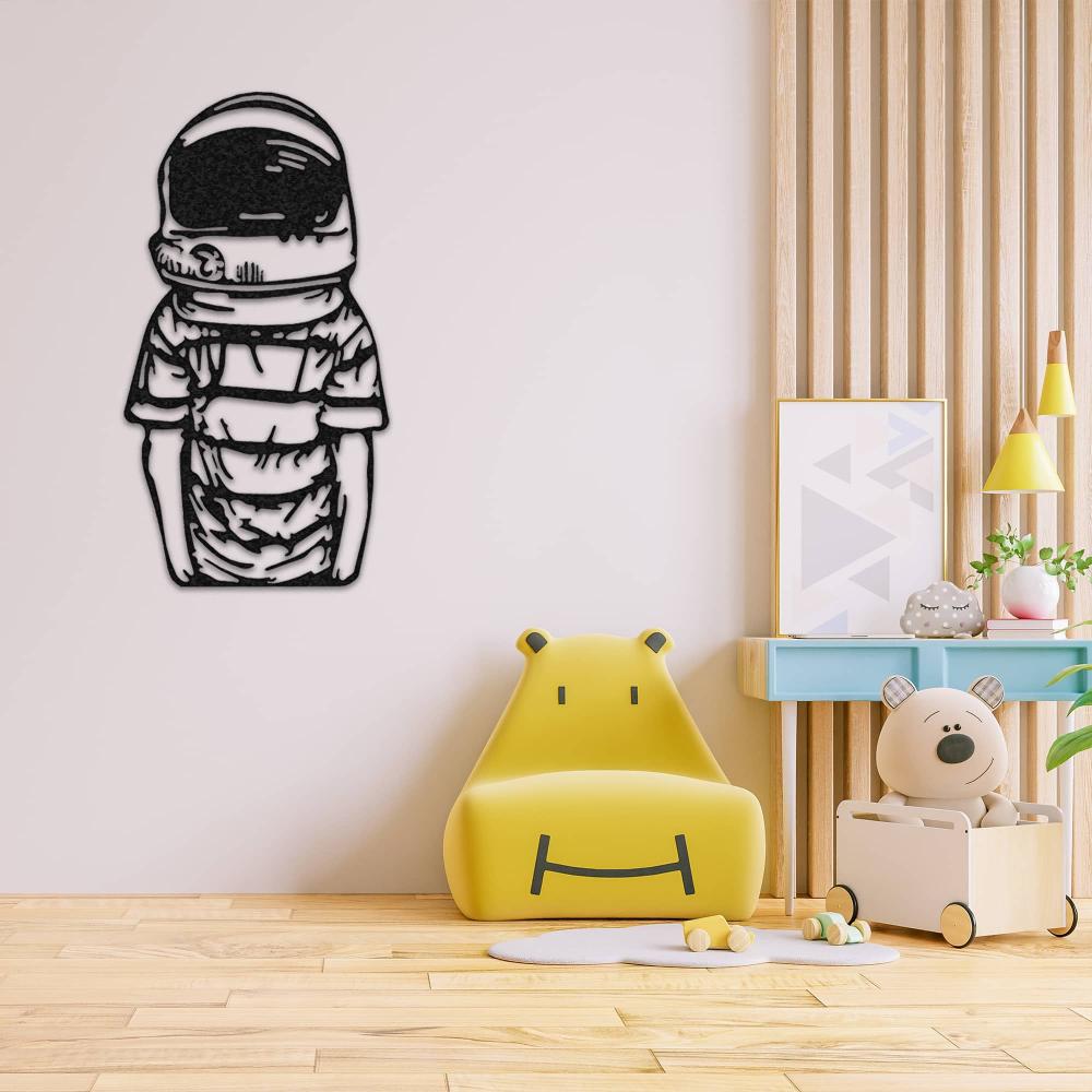 Astronaut metal wall decor showcasing a child-like figure in a spacesuit, mounted on a light wall in a playful children's room with a yellow hippo-shaped chair, a toy storage box, and colorful decorative elements.