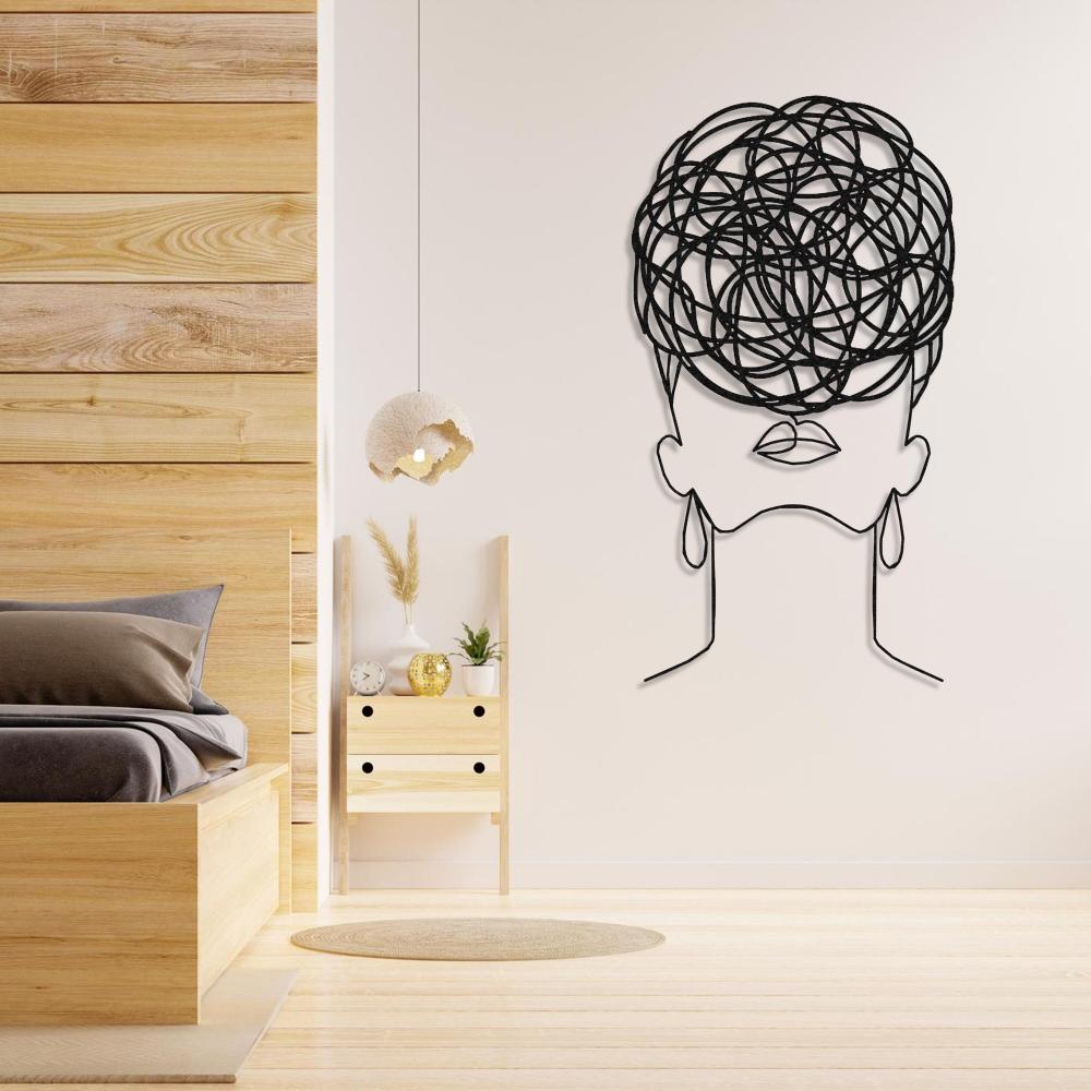 Metal wall art of a woman with circular patterns for hair, displayed in a cozy bedroom setting with wooden furniture and warm lighting.