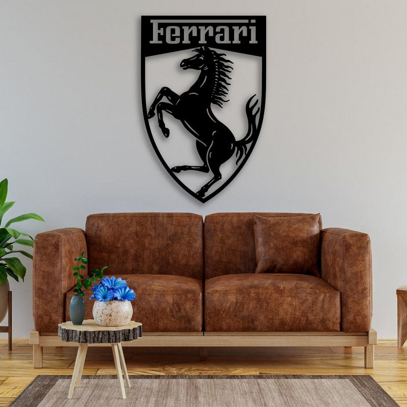 Black Ferrari-themed metal car logo wall art featuring a prancing horse mounted above a brown leather sofa in a cozy living room setting with natural wood and green plant accents.
