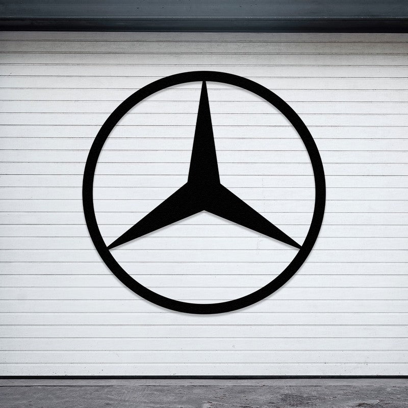 Black Mercedes-Benz-inspired metal car logo wall art mounted on a sleek white-paneled wall in an outdoor or garage setting.