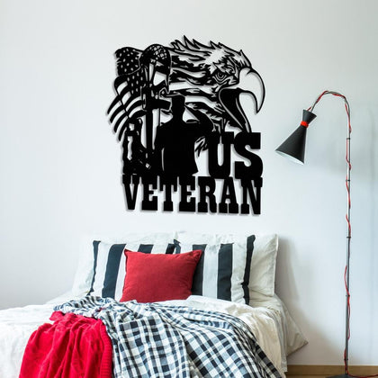 Black patriotic metal wall art featuring a US veteran design with a bald eagle, American flag, military helmet, and saluting soldier silhouette, mounted above a bed with striped pillows and a red throw blanket.