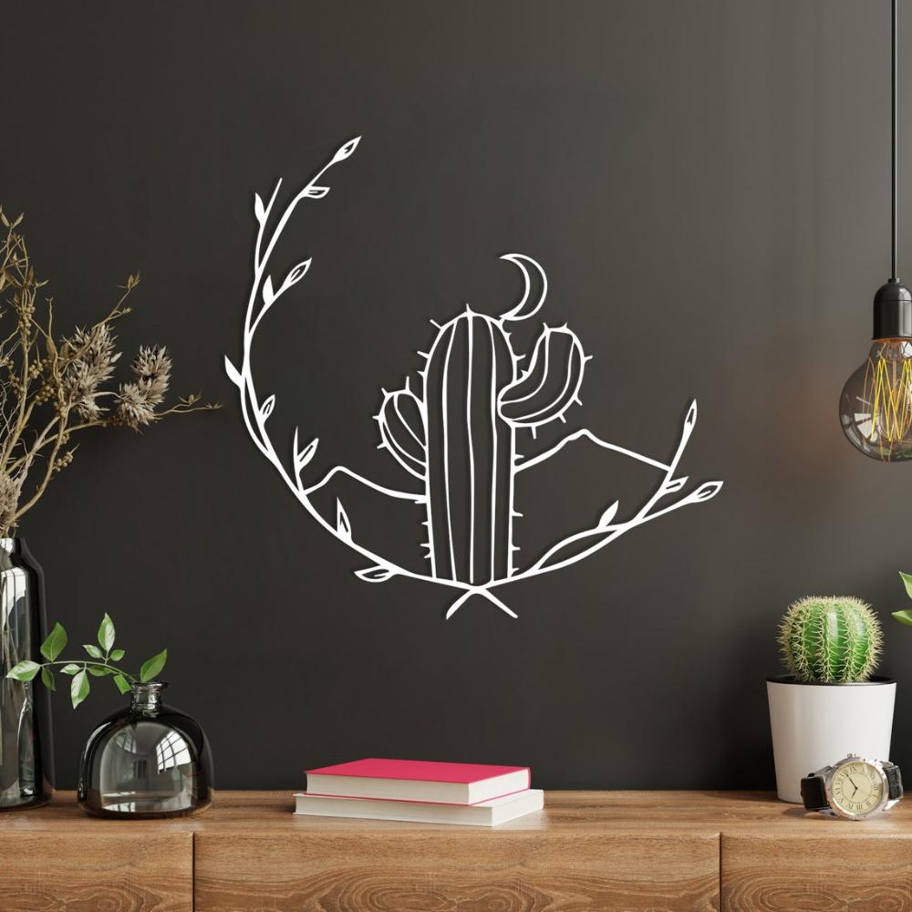 Stylish white Cactus and Moon Metal Wall Ornament mounted on a dark wall, featuring a crescent moon, cactus, and leaf details. The decor is accompanied by a modern setup with books, glass vases, and a cactus plant on a wooden surface.