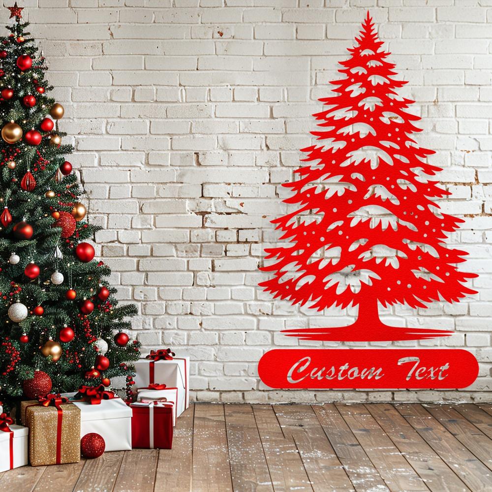 Red painted metal Christmas tree wall art with customizable text, displayed next to a festive Christmas tree and wrapped gifts on a wooden floor with a white brick wall backdrop.