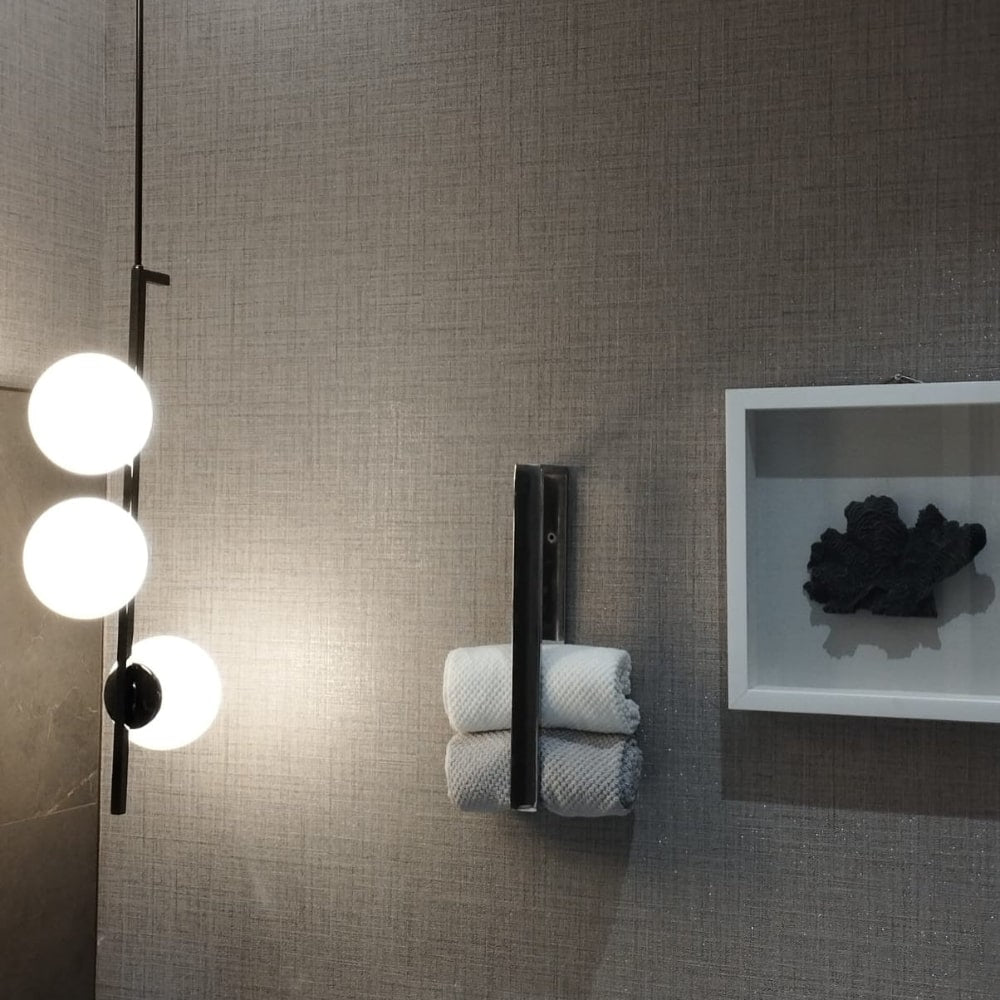 A bathroom setup with a chrome towel holder and modern lighting, emphasizing the reflective finish of the holder