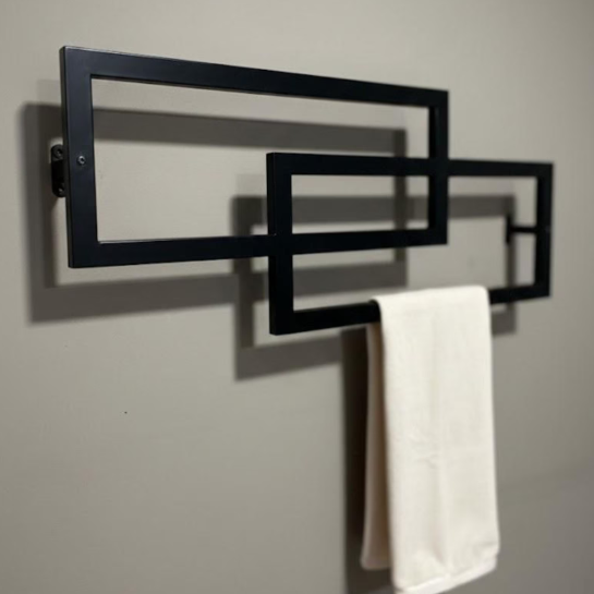 Black wall-mounted towel rack with a white towel on a gray wall