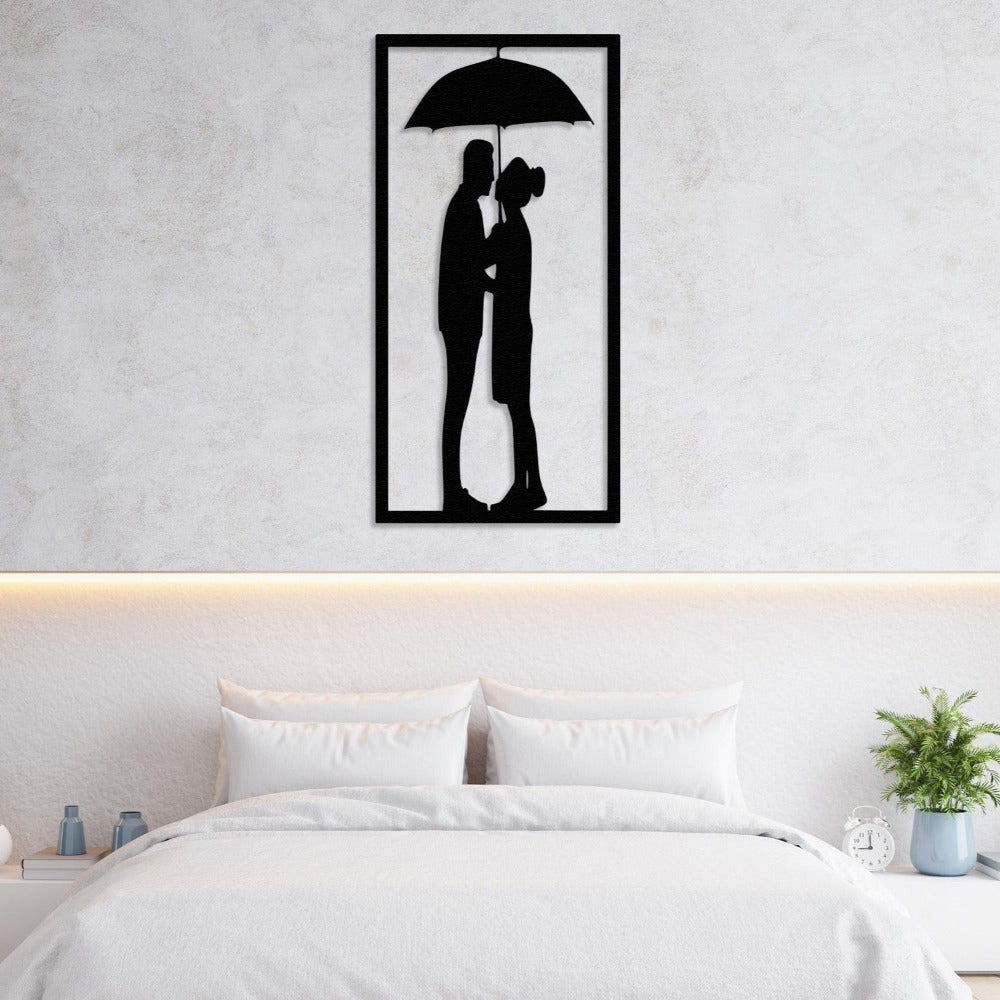 Black metal wall art featuring a couple under an umbrella, elegantly displayed above a minimalist white bed for a cozy and romantic bedroom decor.