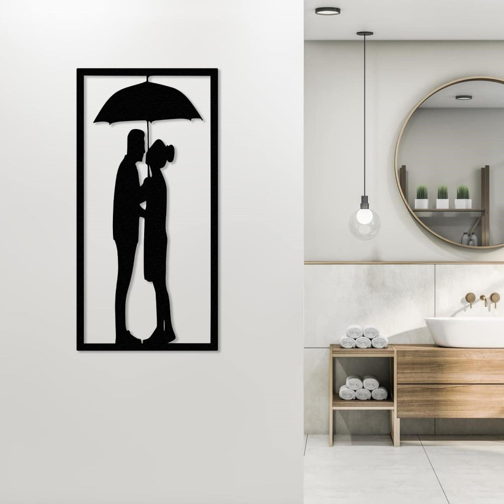 Black metal wall art of a couple under an umbrella, displayed in a modern bathroom setting with minimalist decor and wooden accents.