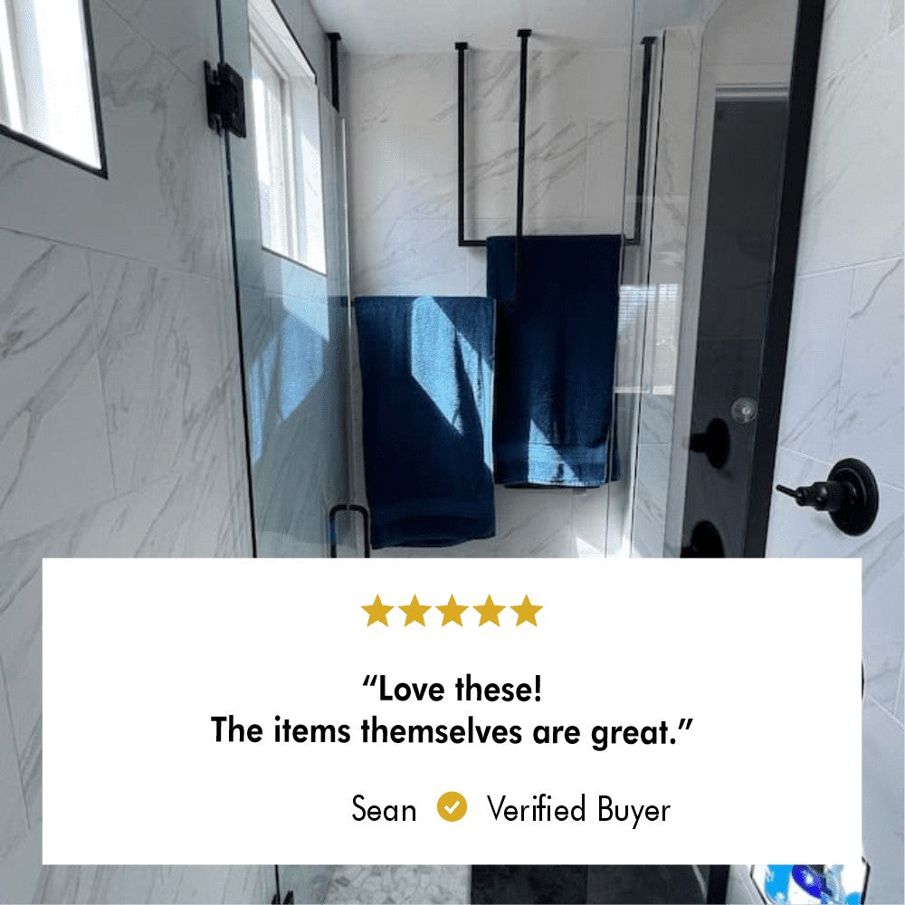 Customer bathroom with ceiling-mounted towel racks holding blue towels, featuring a verified buyer review praising the product's quality.