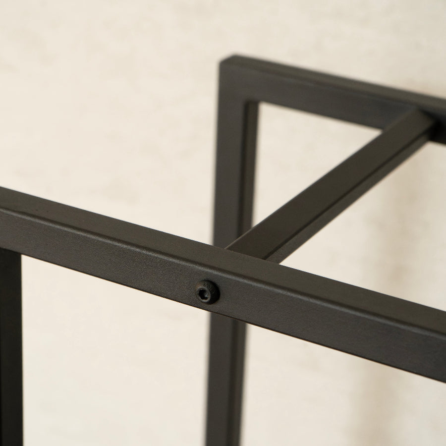 Close-up of a black metal frame against a beige background