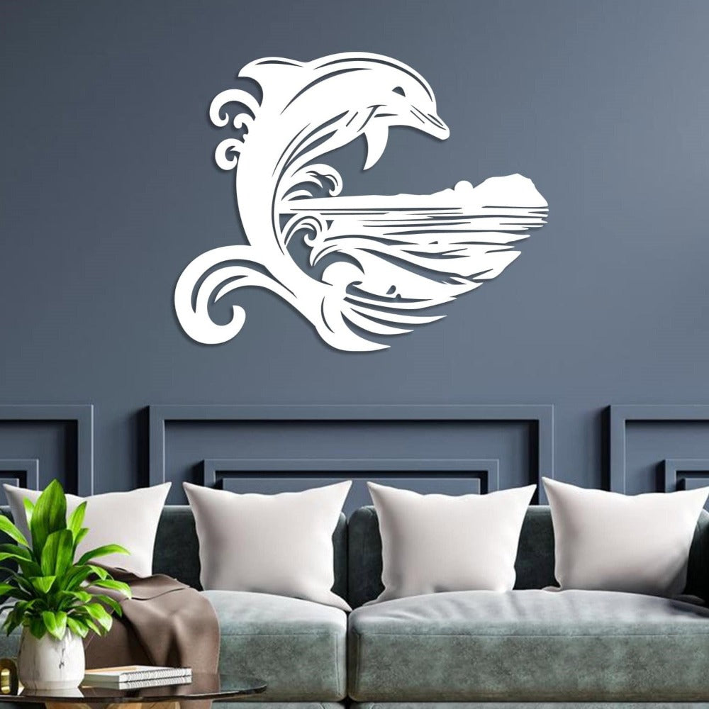 White metal wall art featuring a stylized dolphin jumping over ocean waves with an island silhouette, mounted on a navy blue wall above a gray modern sofa with white cushions and a green plant on a side table.ornament.
