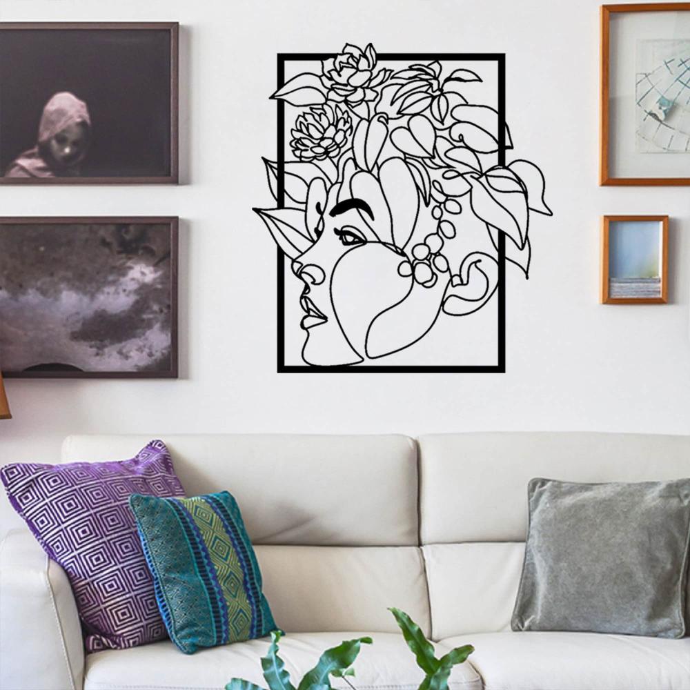 Modern metal wall art of a woman’s face with floral accents, showcased in a living room with white furniture and colorful throw pillows.