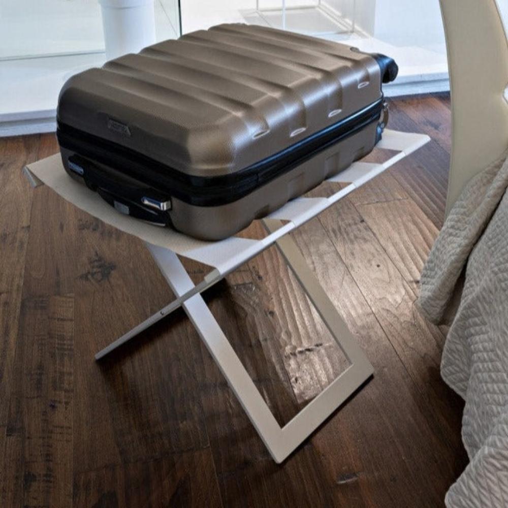 A beige metal luggage rack holding a suitcase, showcasing its durability and suitability for bedrooms with polished wooden floors.