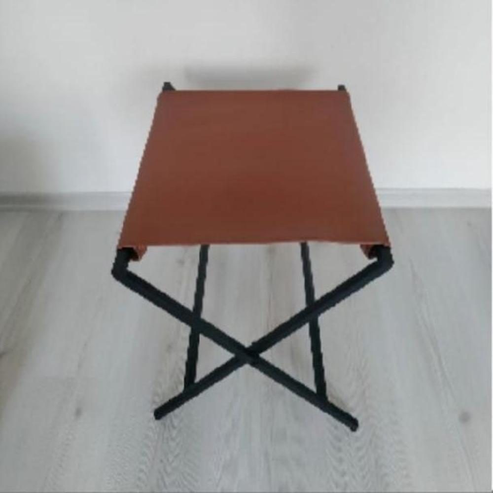 A minimalist foldable metal suitcase rack featuring a genuine leather surface, captured against a plain white background