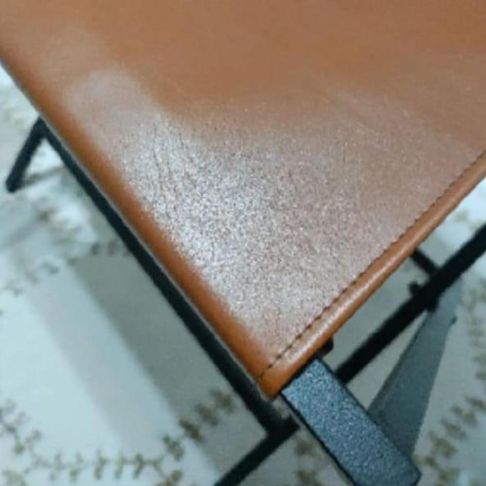 A close-up of the smooth brown genuine leather surface of the foldable suitcase rack, highlighting its premium craftsmanship.