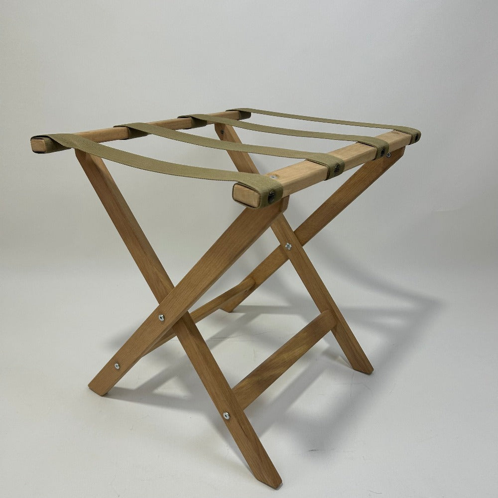 A wooden folding luggage rack captured in a clean studio environment with a white backdrop.