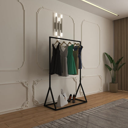 FreeStanding Open Clothes Rail with a black metal frame, holding several dresses on wooden hangers, with shoes and a bag on the bottom shelf in a modern room.