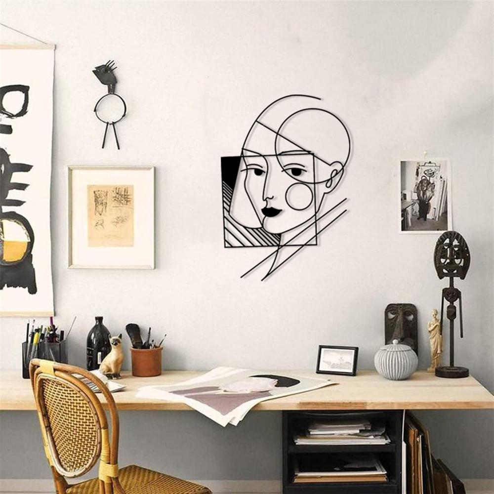 A geometric lady wall art displayed in a creative workspace, surrounded by artistic frames, sculptures, and modern decor.
