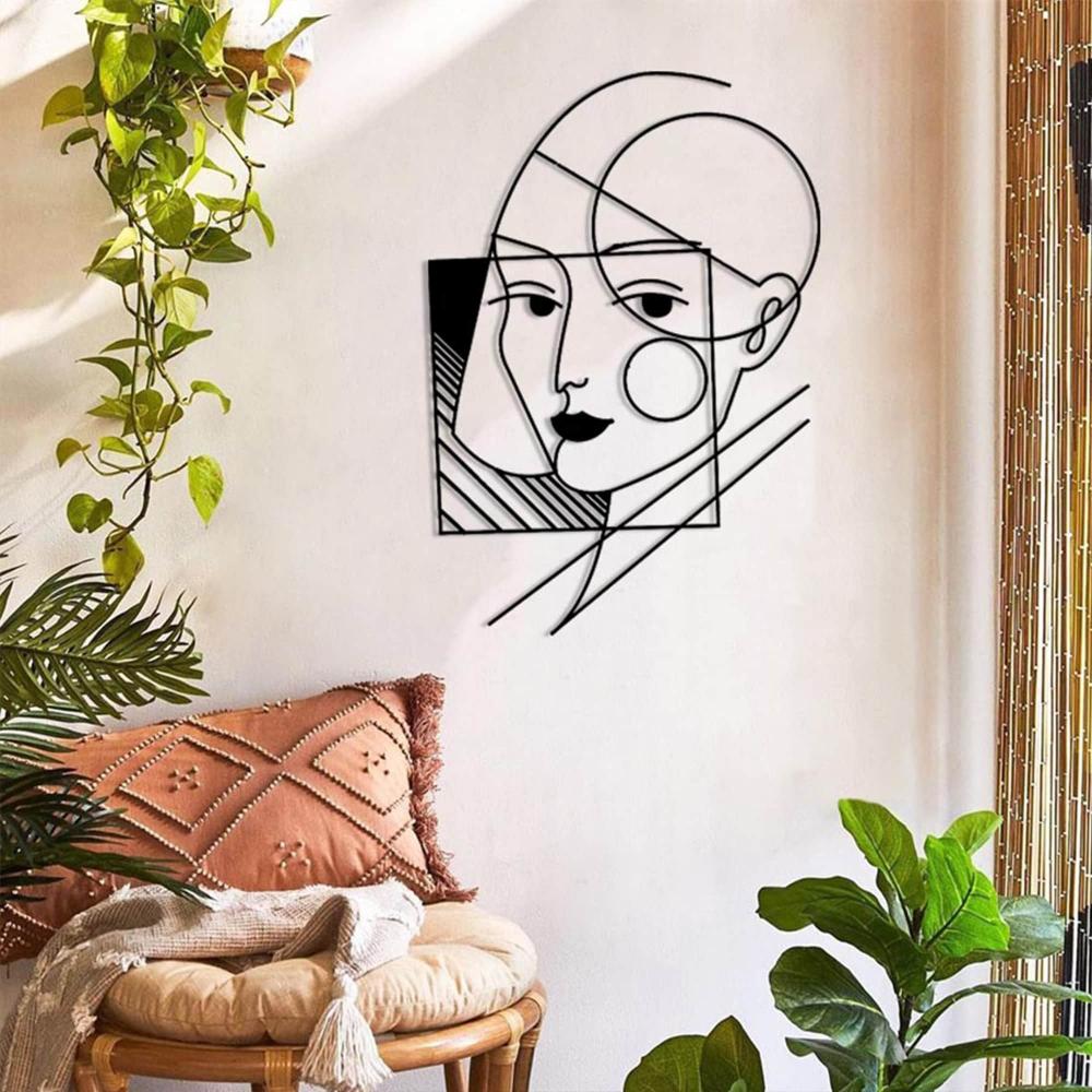 A geometric lady wall art in a boho-inspired living area, adorned with plants, textured cushions, and natural decor elements.