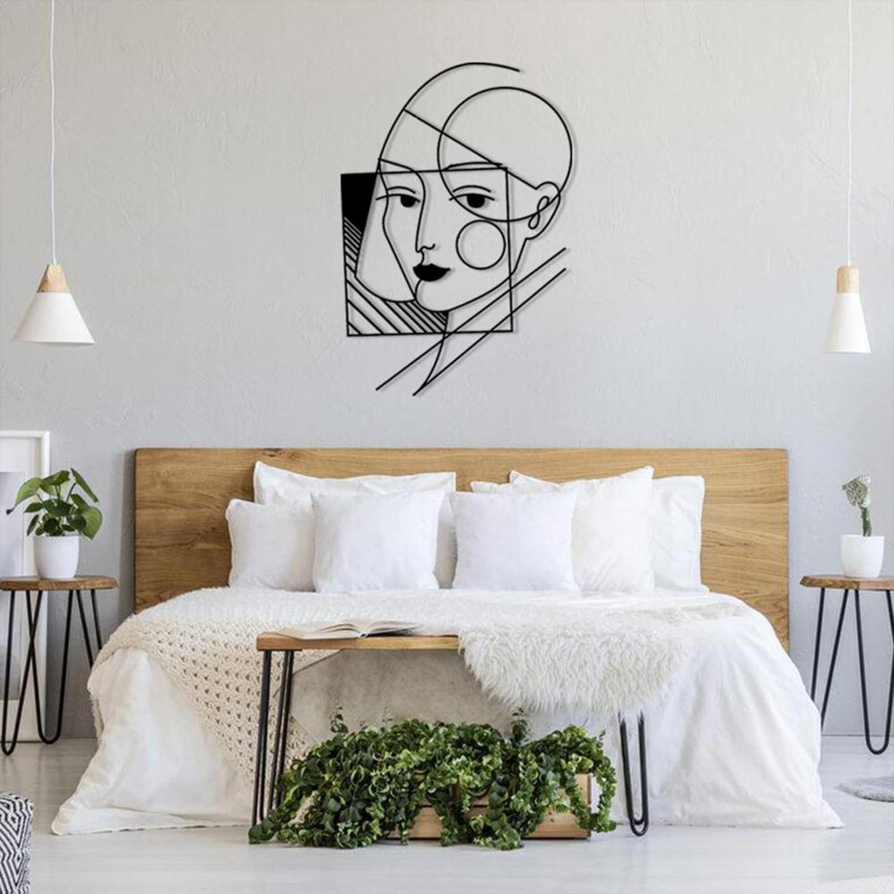 A geometric lady wall art displayed above a modern bed setup, featuring white bedding and a natural wooden headboard.