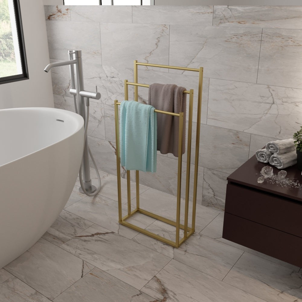 A gold-finished free-standing towel rack holding colorful towels, adding a touch of luxury to a bathroom with a marble design.