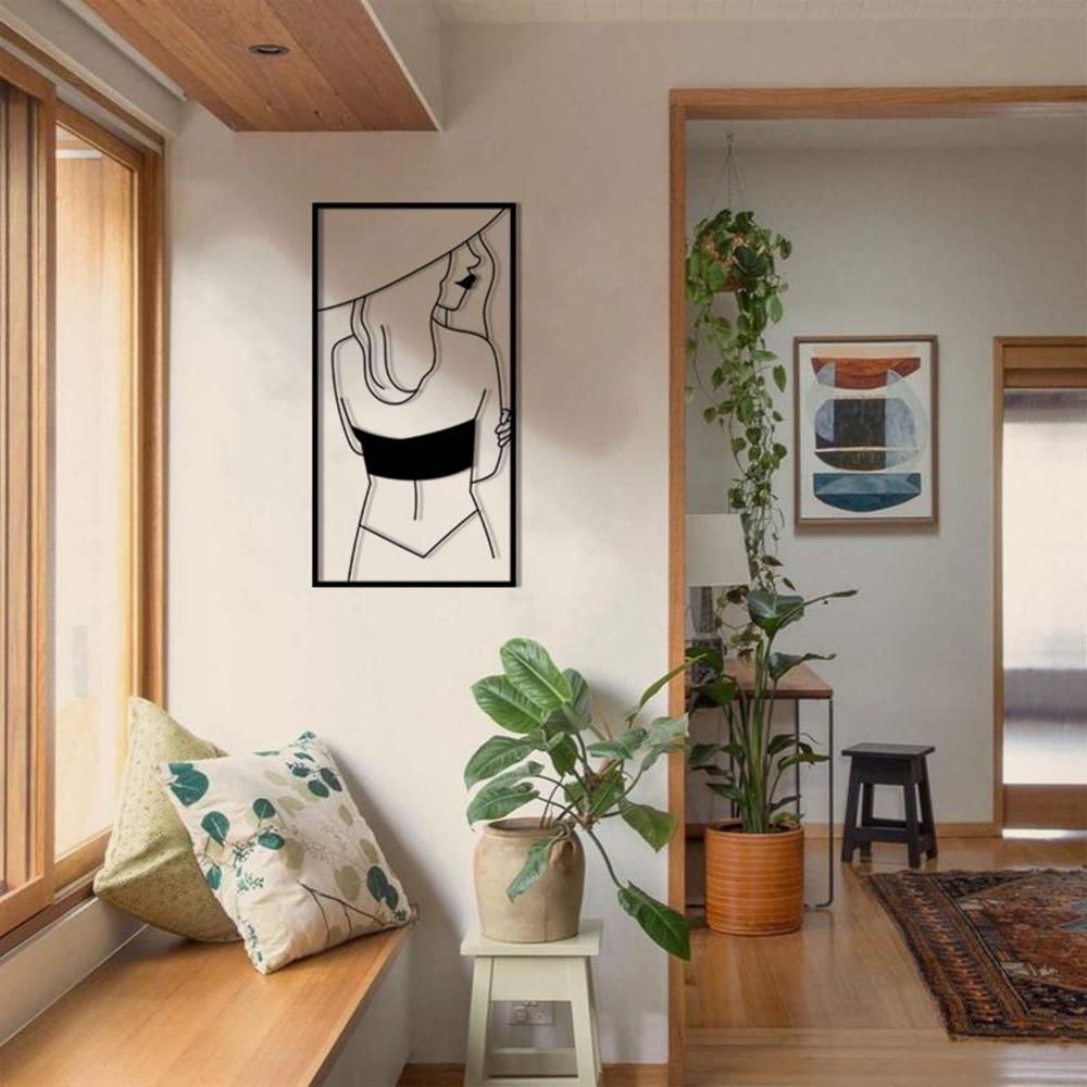Stylish hallway decorated with potted plants and a modern metal wall art of a woman in a hat, adding elegance to the space.