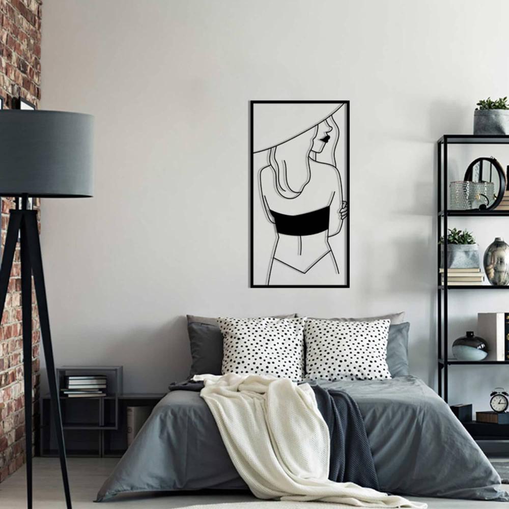 Bedroom with industrial and modern elements, featuring a framed metal wall art of a woman in a hat mounted above the bed.
