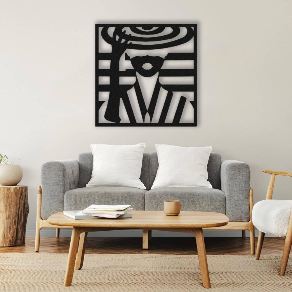 Lady with hat metal wall art in black, mounted above a modern gray sofa with white cushions, complemented by a wooden coffee table, natural elements, and minimalist decor.