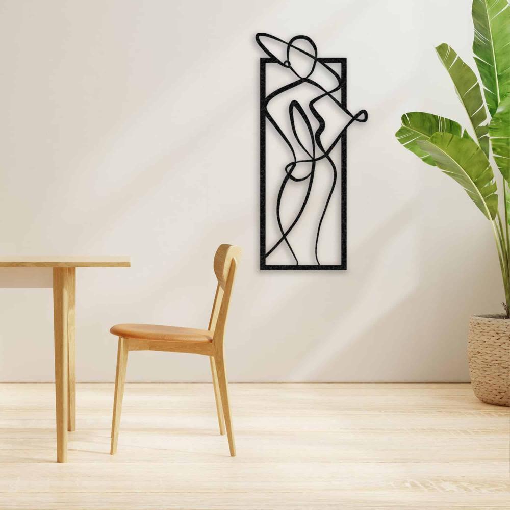 Sleek black metal wall art of a woman in a hat, hung on a light beige wall in a dining area with a wooden table and chair.
