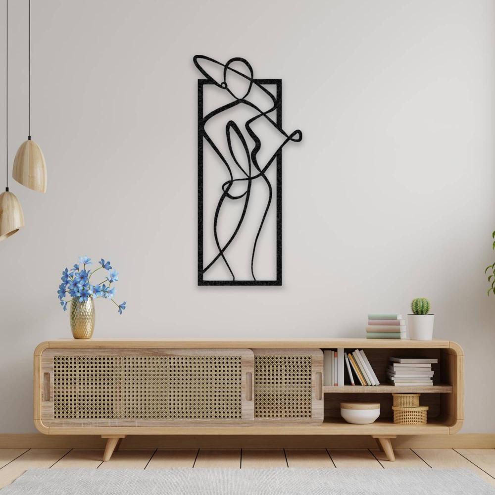 Minimalist metal wall art featuring a woman wearing a stylish hat, displayed on a neutral wall above a wooden console table with a modern design.