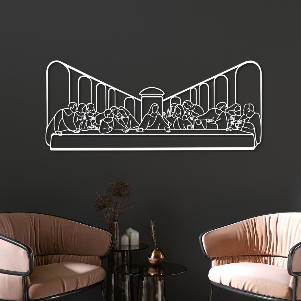 Minimalist white metal wall art depicting "The Last Supper," mounted on a dark wall above a modern arrangement with two beige chairs and a glass coffee table featuring decorative items.