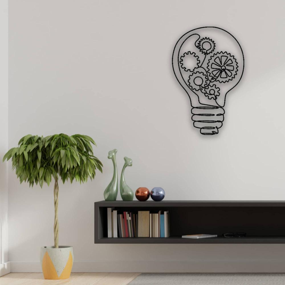 Light bulb-shaped metal wall art with intricate gear designs, mounted on a white wall above a modern black floating shelf styled with books and decorative items, accompanied by a potted tree and artistic ornaments.