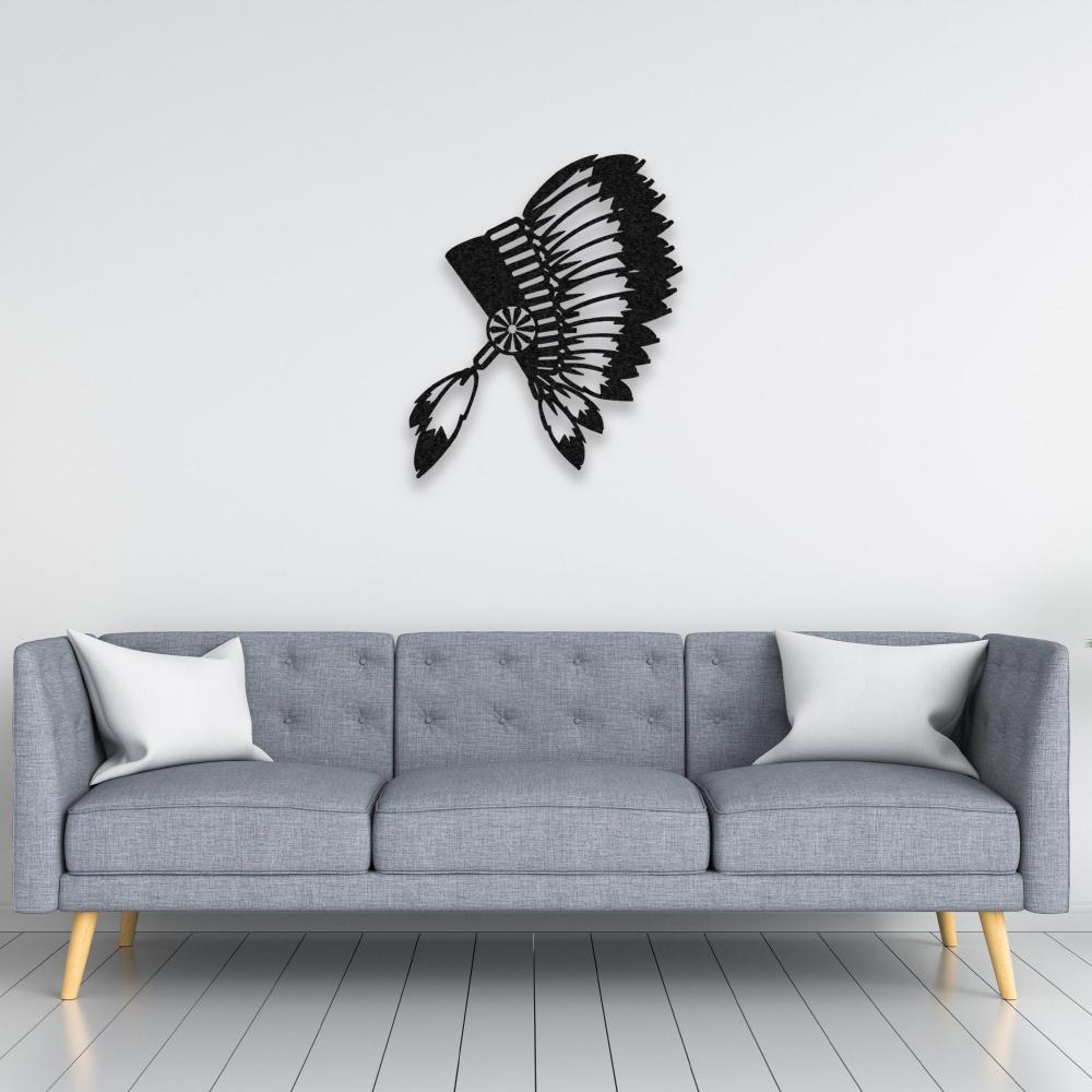 Black metal wall art of an Indian chief's feathered headdress elegantly placed above a tufted grey sofa in a minimalist living space.