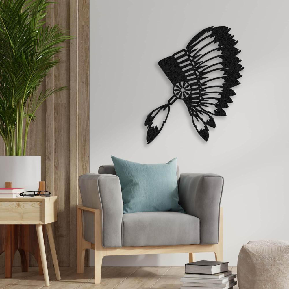 Black metal wall art of an Indian chief's feathered headdress displayed above a modern grey armchair with wooden accents in a cozy living space.