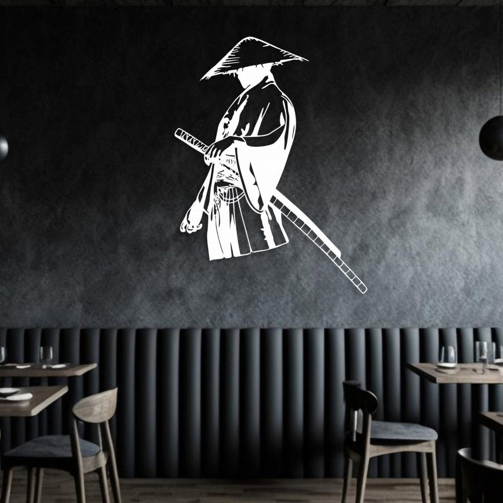 White metal wall art of a solitary samurai holding a katana, wearing a traditional straw hat, mounted on a dark textured wall in a modern dining area with wooden chairs and tables.