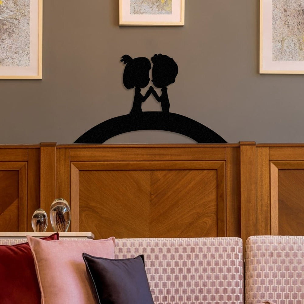 Romantic metal wall art depicting a couple on a bridge, styled as home decor above a wooden headboard in a cozy interior setting.