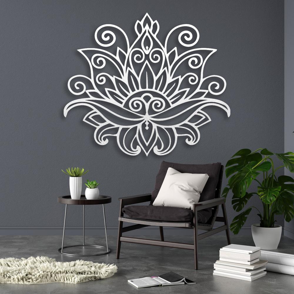 Mandala lotus metal wall art in white with intricate floral patterns, mounted on a dark gray wall, complementing a modern living space featuring a black armchair, potted plants, and minimalist decor.