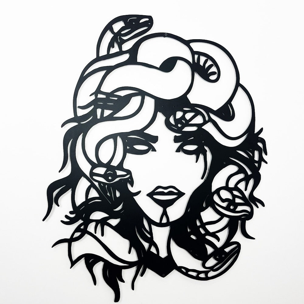 Close-up view of Medusa-inspired metal wall art featuring intricate details of snakes and her face against a plain white background.