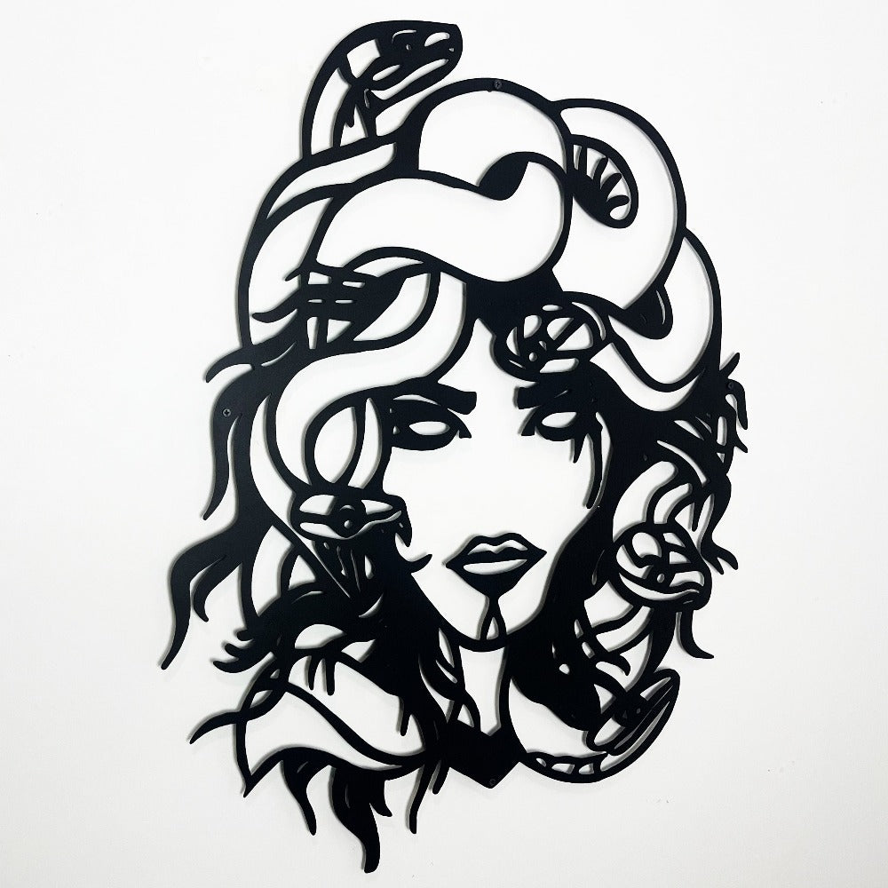 Detailed metal wall art of Medusa featuring bold lines and snake motifs entwined in her hair against a clean white background.
