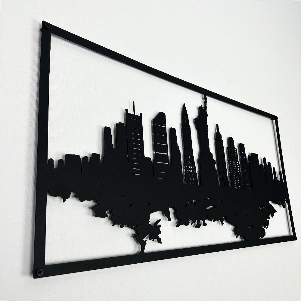 Close-up angled view of black New York City skyline metal wall art, showcasing detailed cutouts of buildings and the Statue of Liberty with a minimalist white background.