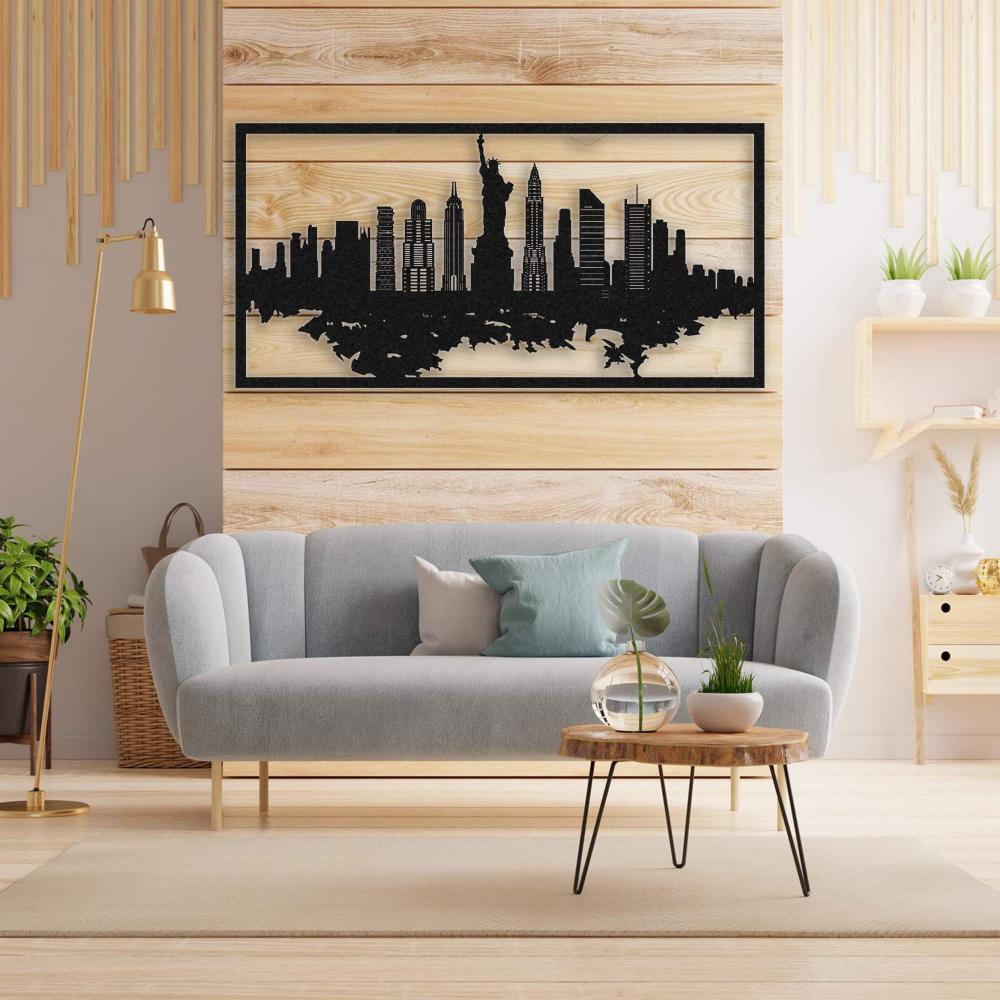 Modern living room featuring a light gray curved sofa with accent pillows, a round wooden coffee table with black metal legs, and potted plants. The wall is adorned with a black New York City skyline metal wall art mounted on light wooden paneling, creating a stylish and warm ambiance.