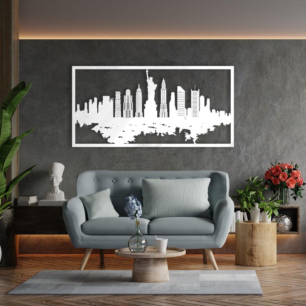White New York City skyline metal wall art featuring the Statue of Liberty and iconic buildings, mounted on a dark textured wall above a modern gray sofa with light blue cushions in a contemporary living room setting.